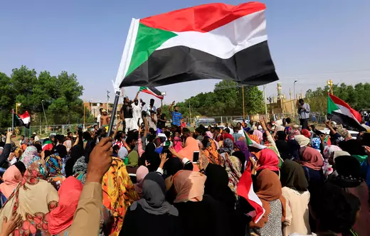 Sudanese people chant slogans and wave their national flag as they celebrate on the streets of Khartoum, Sudan, after the country's ruling military council and a coalition of opposition groups reached an agreement to share power during a transition period leading to elections, on July 5, 2019