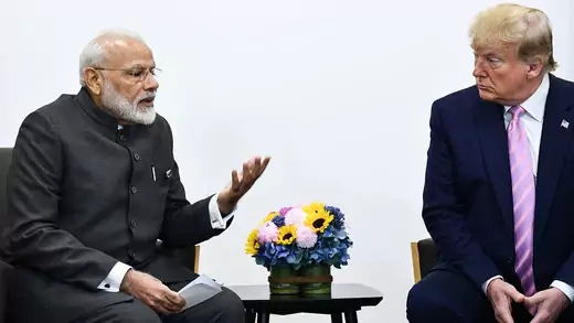 Indian Prime Minister Modi speaks to U.S. President Donald Trump. They both sit in chairs next to each other.