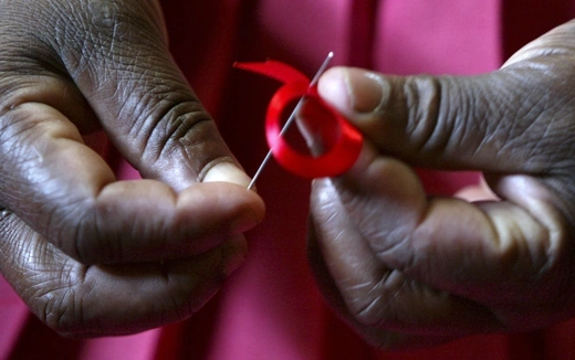 A Kenyan woman prepares a ribbon in honor of World AIDS Day in Nairobi, Kenya on November 25, 2004