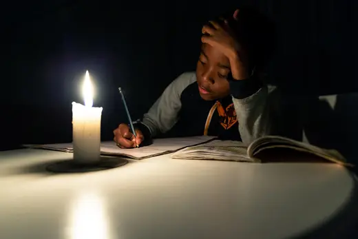 A Zimbabwean boy does his homework under candlelight in Harare.