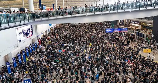 Hundreds of protesters in black shirts completely fill the terminal of the Hong Kong airport.