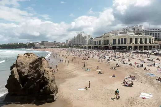 People swim in the sea and walk on the beach in Biarritz.