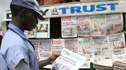 A man looks at a newspaper headline in front of a newspaper stand in Abuja, Nigeria.