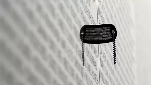 A dog tag is wedged between panels of the Vietnam Veterans Memorial in Washington, DC.