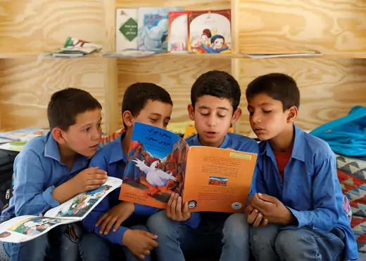 Afghan boys reading inside a mobile library bus in Kabul, Afghanistan.