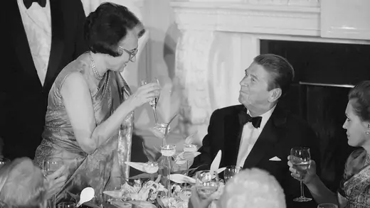 Indira Gandhi holds a glass during a dinner with Ronald Reagan. 