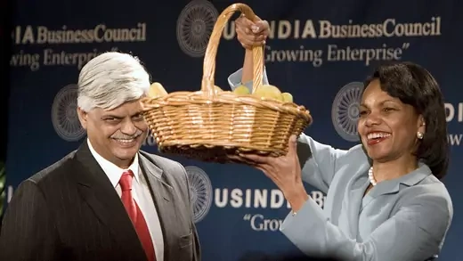 Condoleezza Rice holds a basket of Indian mangoes during a press conference.