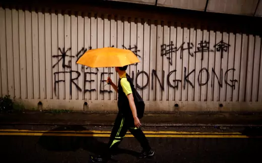 A man walks past a graffiti during a march to demand democracy and political reforms in Hong Kong, China, August 18, 2019.