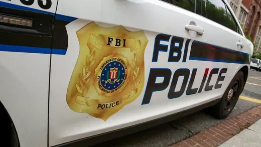 A car is parked on the street that says "FBI Police" on it.