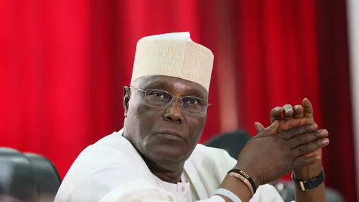 Atiku Abubakar sits and clasps his hands at a meeting in Abuja. 