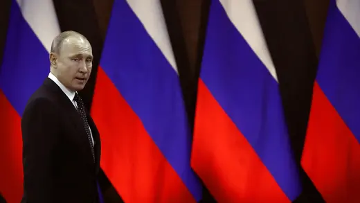 Russian President Vladimir Putin walks past Russian flags in April 2019.