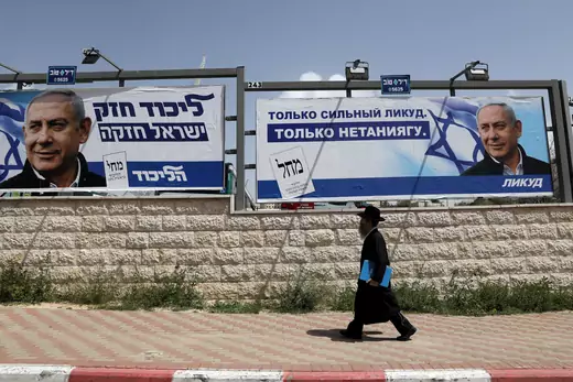 An Orthodox Jewish man walks past an election campaign poster in Jerusalem.