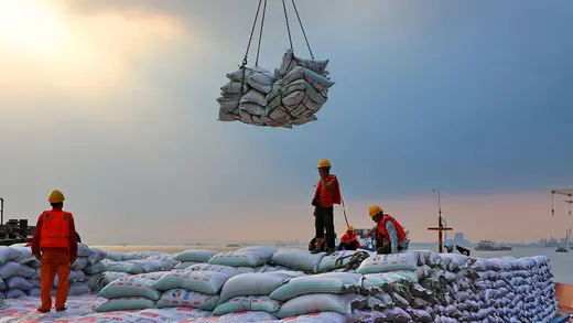 Workers transfer sacks of soybeans imported from Brazil at a Chinese port.
