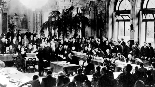Representatives from France, Germany, and the United Kingdom meet at the Lausanne Conference of 1932 to discuss suspending reparations imposed on countries defeated in World War I.