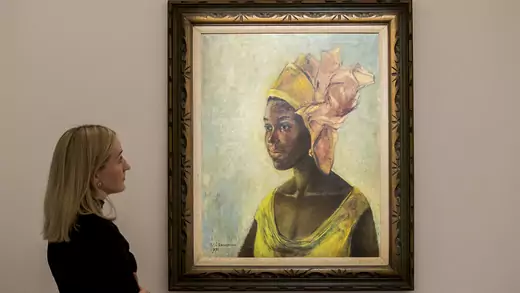 A women looks at the painting "Christine," by Ben Enwonwu.