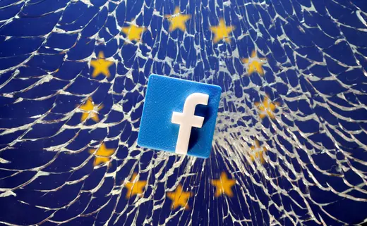 A 3D printed Facebook logo is placed on broken glass above a printed EU flag in this illustration taken.