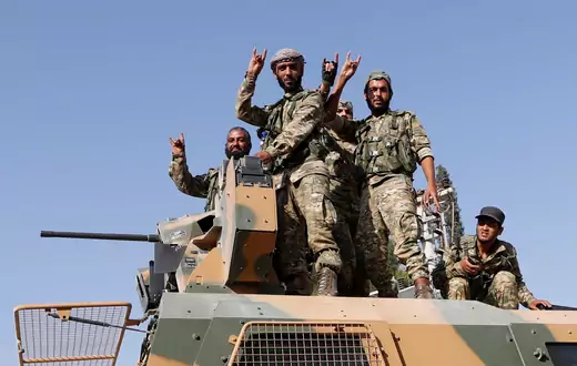 Members of the Syrian National Army on top of an armored vehicle in Ceylanpinar, Turkey.