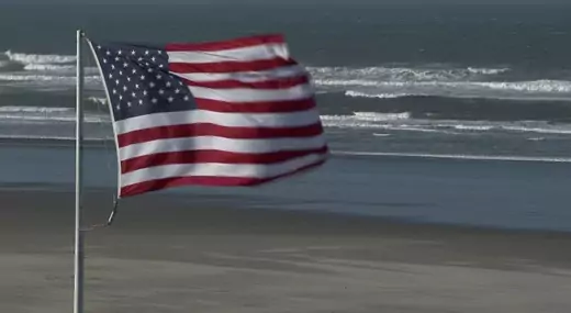 An American flag flies on the edge of the Atlantic ocean. 