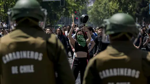 A protester hits a frying pan.