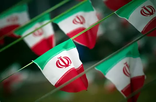 A line of Iranian flags wave in a square in Tehran. 