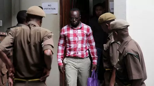 Tanzanian investigative journalist Erick Kabendera arrives, flanked by security, at the Kisutu Residents Magistrate Court