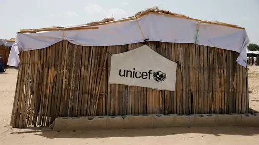 A banner with the UNICEF logo is seen hanging on a makeshift school at an internally displaced persons camp on the outskirts of Maiduguri, northeast Nigeria, on June 6, 2017.