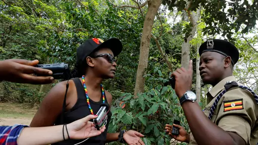 Uganda police officers question a member of Uganda's LGBT community during their pride parade in Entebbe, near  Kampala, before police asked LGBT members to abandon their gathering, on September 24, 2016.