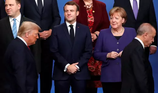 French President Emmanuel Macron and German Chancellor Angela Merkel look on as U.S. President Donald J. Trump and Turkish President Recep Tayyip Erdogan walk at the NATO leaders summit in Watford, United Kingdom, on December 4, 2019. 