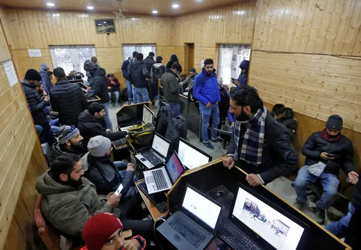 Journalists use the internet as they work inside a government-run media centre in Srinagar