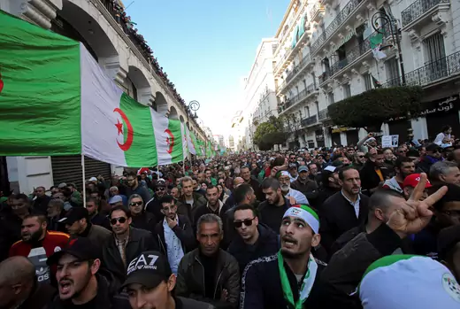 Demonstrators carry a national flag during an anti-government rally in Algiers, Algeria January 3, 2020.