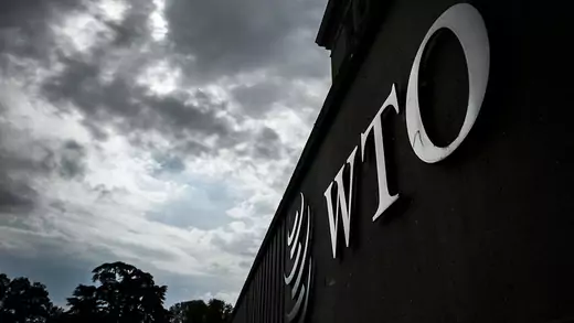 The WTO sign on a building against a stormy sky