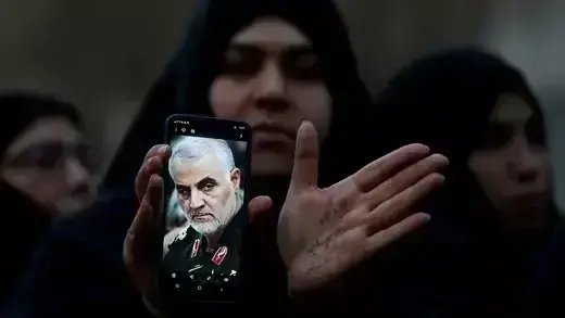 An Iranian woman shows a photo of Iranian Commander Qasem Soleimani on her cell phone during a protest against his killing in Tehran.