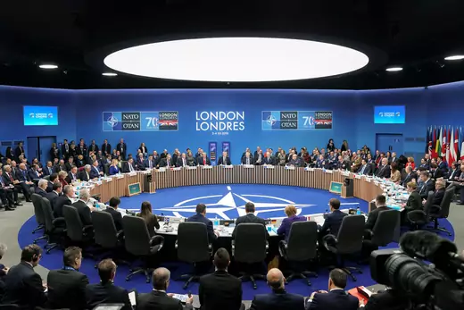 NATO leaders meet at summit in Britain around a table.