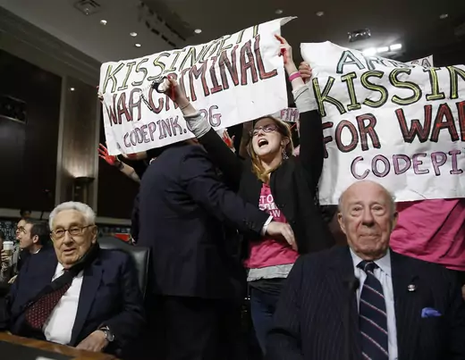 Code Pink demonstrators surround former United States Secretaries of State Henry Kissinger (L) and George Shultz (R) before the beginning of the Senate Armed Services Committee on global challenges and U.S. national security strategy on Capitol Hill in Washington January 29, 2015.