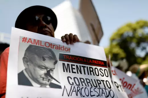 A demonstrator holds a sign during a march against Mexico's president Andres Manuel Lopez Obrador as he delivers his first state of the union in Mexico City, Mexico, September 1, 2019. The sign reads, "#AMLO traitor. Liar. Corrupt. Narco-state".