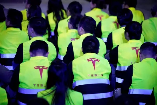 Employees of Tesla are seen during a delivery event for Tesla China-made Model 3 cars in Shanghai