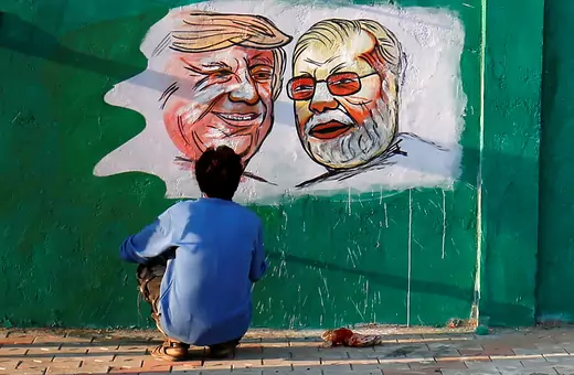 A man applies finishing touches to paintings of U.S. President Donald Trump and India's Prime Minister Narendra Modi on a wall as part of a beautification along a route that Trump and Modi will be taking during Trump's upcoming visit, in Ahmedabad, India, February 17, 2020.