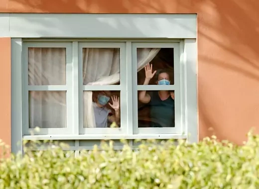 Guests, wearing protective face mask, look through a window at H10 Costa Adeje Palace, which is on lockdown after cases of coronavirus have been detected there in Adeje, on the Spanish island of Tenerife, Spain.