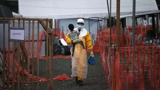 Un trabajador de Médicos Sin Fronteras lleva a un niño sospechoso de tener Ébola en un centro de tratamiento en Paynesville, Liberia, en octubre de 2014.
