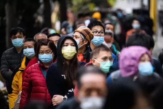 People wearing facemasks as a preventative measure following a coronavirus outbreak which began in the Chinese city of Wuhan, line up to purchase face masks from a makeshift stall after queueing for hours following a registration process during which they were given a pre-sales ticket, in Hong Kong on February 5, 2020.