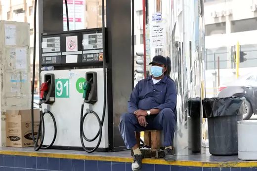 A gas station worker wearing a protective face mask sits next to a petrol station, after Saudi Arabia imposed a temporary lockdown on the province of Qatif following the spread of coronavirus, in Qatif, Saudi Arabia March 9, 2020. REUTERS/Stringer