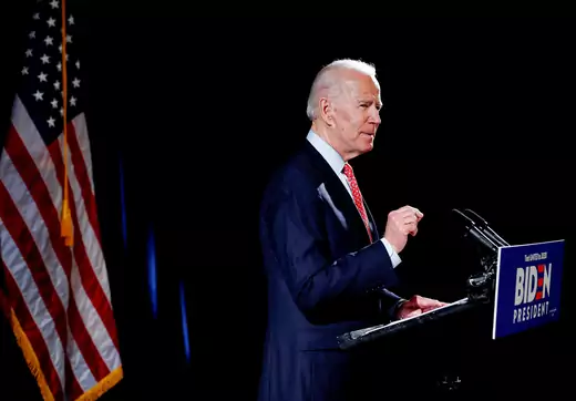 Former Vice President Joe Biden stands behind a podium and in front of American flags while he speaks on the coronavirus pandemic in Wilmington, Delaware, on March 12.