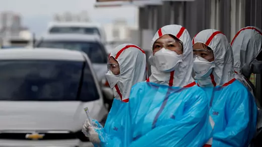 Medical staff in protective gear work at a 'drive-thru' testing center for COVID-19 in Yeungnam University Medical Center in Daegu, South Korea, on March 3, 2020.