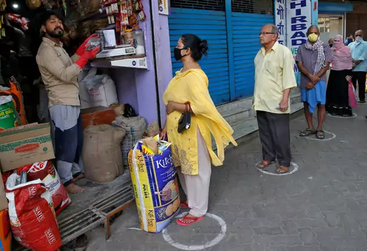 People queue standing in circles drawn to maintain safe distance as they wait to buy grocery items during a 21-day nationwide lockdown to limit the spreading of Coronavirus disease (COVID-19), in Kolkata, India.