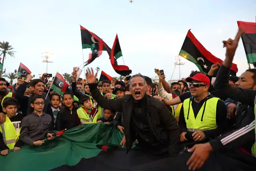 Libyan protesters shout and wave Libyan flags while demanding an end to Khalifa Haftar's offensive against Tripoli. 