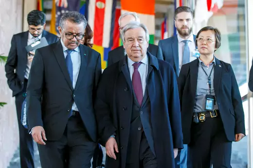 World Health Organization Director General Tedros Adhanom Ghebreyesus and UN Secretary General Antonio Guterres, flanked by staff members, walk toward a briefing at WHO headquarters in Geneva, Switzerland.
