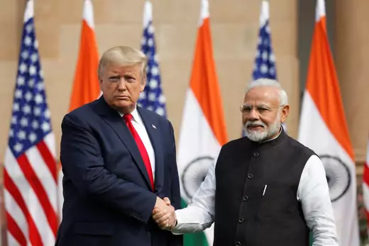 U.S. President Donald J. Trump shakes hands with Indian Prime Minister Narendra Modi in front of U.S. and Indian flags.