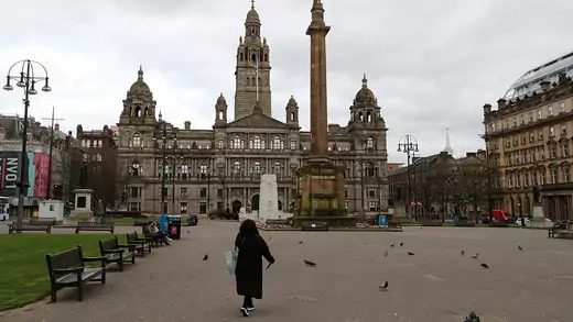 A person walks in an empty square in Glasgow. 