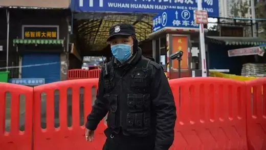 A security guard wears a mask in front of a blocked animal market in Wuhan, China.