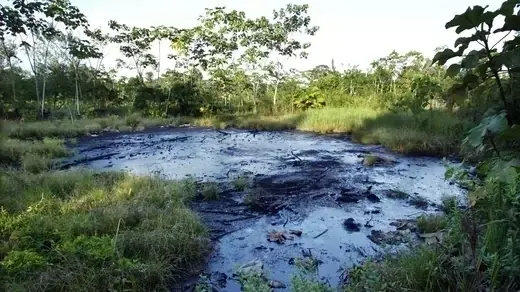 A waste pit filled with crude oil left by Texaco drilling operations lies near the Amazonian town of Sacha, Ecuador.